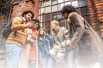Group of young multiethnic friends on coffee break, looking at mobile phone