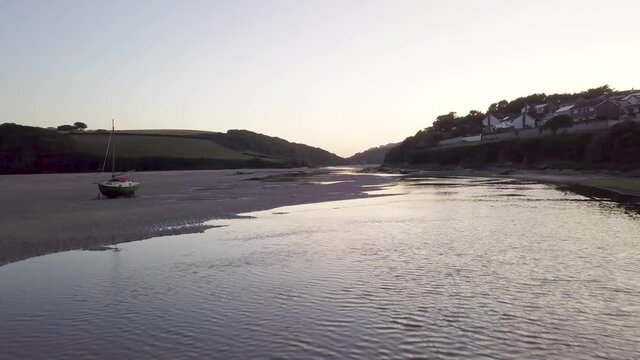 Drone Flying Over Sandy Bottom Of River Gannel During Low Tide At Sunrise In Newquay, England, UK. - low aerial