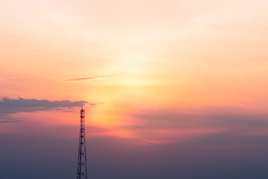 A view of the signal tower at sunset in vibrant orange pinks and violet colors.