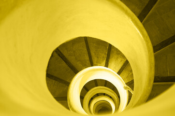 Yellow and gray, Color of the year of 2021 Illuminating. Old stairs in spiral staircase with hand