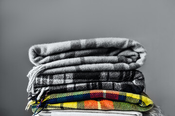 Stack of woolen checked blankets, autumn and winter concept, gray image with trendy color of 2021