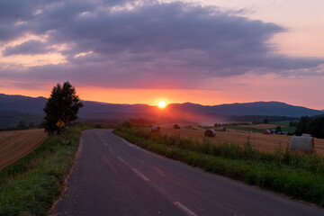夏の美瑛町の夕景 夕陽と麦稈ロールの風景