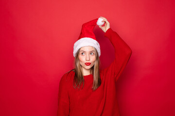 Portrait of woman looking at copyspace having thoughts about future events wearing cap hat over red...