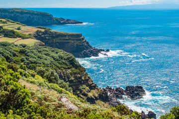 Fototapeta na wymiar Hiking on cliffs with vegetation next to the turquoise water Atlantic Ocean in Terceira, Azores PORTUGAL