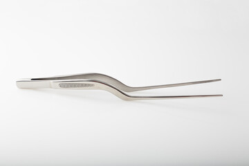 Metal chef tongs to decorate gourmet dishes, which help put small ingredients on the plate.