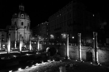 The monuments of rome in black and white at night.	