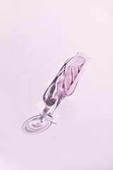 Vertical shot of champagne glasses with shadow on a pink background