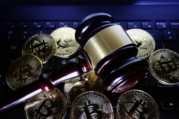 Legal gavel and bitcoins on computer keyboard