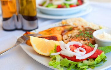 Greece food - Grilled salmon and vegetables on white plate