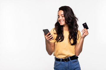 Image of a beautiful young excited pretty woman using mobile phone holding credit card posing isolated over white background