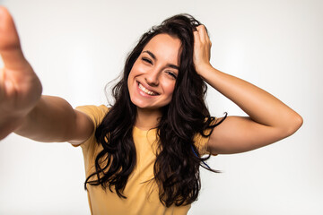 Fototapeta premium Beautiful woman taking self picture with smartphone camera isolated on white background