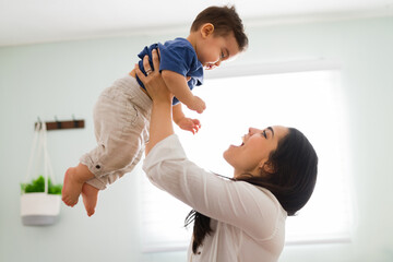 Playing mother having great time with son at home
