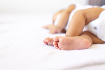 Close up of little feet newborn baby lying on a comfortable bed at home