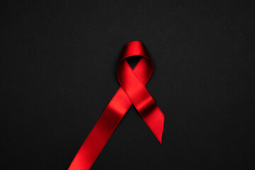 Aids day. Red ribbon symbol in hiv world day on dark background. Awareness aids and cancer. Healthcare and medical concept.
