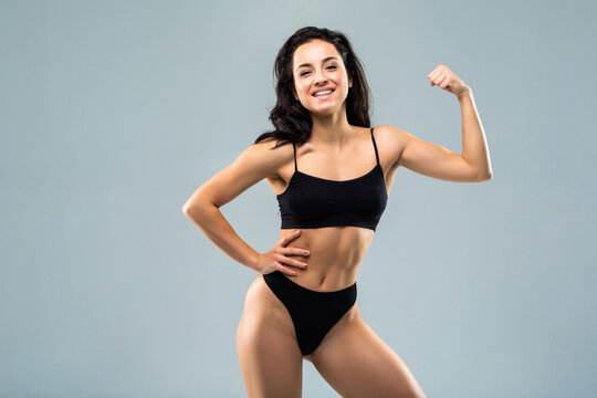 Sport Fitness Woman Flexing Show Her Biceps Muscles, Young Smile Girl Athletic Body, Perfect Figure Wear Black Panties Isolated Over White Background