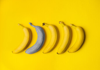One gray banana surrounded by yellow bananas. The concept of differentiating from the crowd. Creative banner with colors of the year 2021 - Illuminating and Ultimate Gray - 398375779