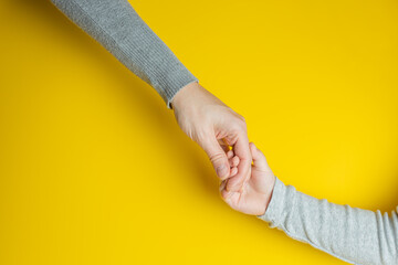 Mom and child in gray clothes holding hands on yellow background. Creative banner with two colors of the year 2021 - Illuminating and Ultimate Gray. - 398375797