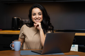 Woman drinking tea while on her laptop working from home in quarantine lockdown. Social distancing Self Isolation