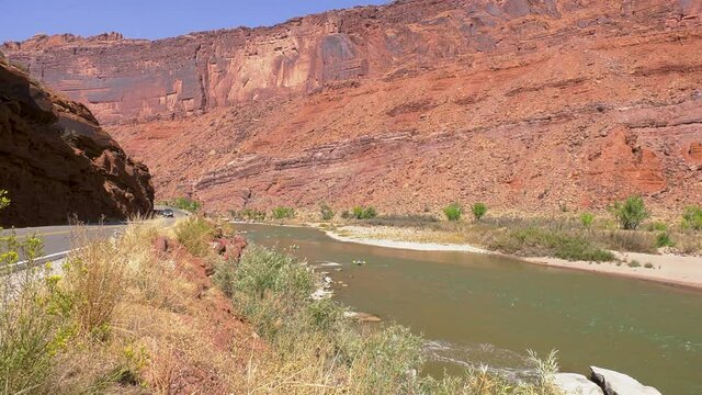 Colorado river flowing through red rock mountains with rafters 