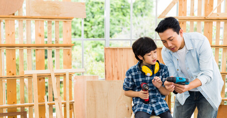 Asian father is teaching his son woodworking.
