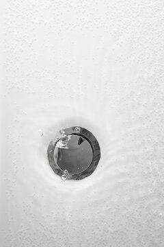 bathtub drain with water and bubbles