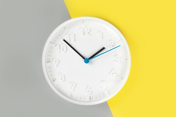 Plain wall clock in the center of grey and yellow background. Ten o'clock. Close up banner with...