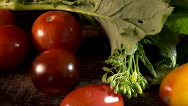 Slider to the left extreme closeup of broccoli rabe and cherry tomatoes.