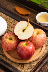 Fresh fruits and small apples on the background of retro Chinese style tea tray