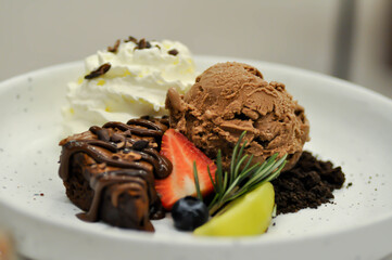 brownie , chocolate ice cream with whipping cream and strawberry