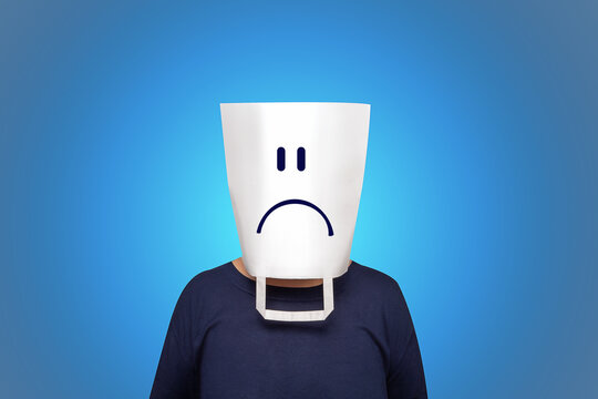 Blue monday concept. The most depressing day of the year. White pocket with sad face on head. Blue background. Negative qualities and feelings of person. Tired office staff. 