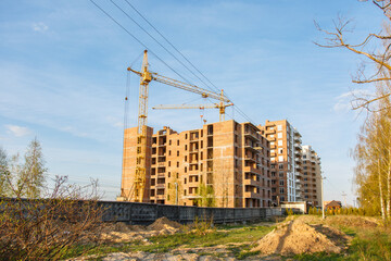 Fototapeta na wymiar Construction of new house or building. General view. Unfinished cement building in the summer. The introduction of urbanization into nature. Capital construction in Ukraine. Tower crane
