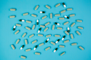 Spilled colored pills on a blue background. Pharmacology and medicine struggle for health. Treatment and prevention of viral diseases. Medicine and health concept.Medication and prescription pills