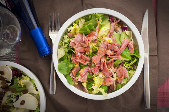 Bowl of a salad with different vegetables, lacon and honey