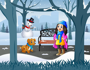 A girl with her pet walking in the snowy park