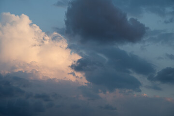 Obraz premium Beautiful sky background. Light blue sky with dramatic orang, pink, and gray clouds. Perfect for sky replacement. High quality photo