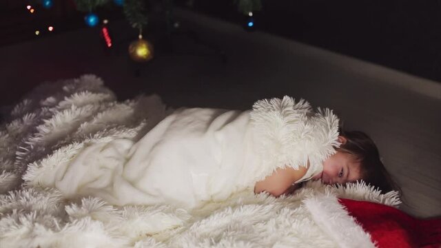 a child in red clothes is sitting waiting for the new year. the concept of celebrating Christmas at midnight. holiday costume