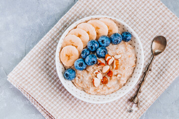 Plate of oatmeal with blueberries, banana and almonds top view