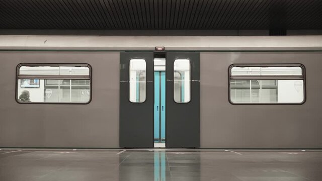 The subway train closes the doors and leaves. Empty underground platform at night. The last train leaves for the depot. Side view