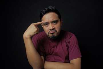 asian man thinking with hand on forehead with mouth pulled up, use your brain or doubt illustration