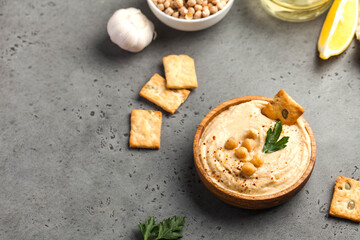 hummus in a wooden plate with parsley and croutons. Dishes of chickpeas, a vegetarian dish. Copy space.