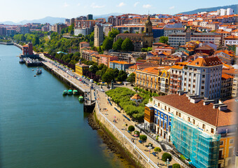 Fototapeta na wymiar View from Vizcaya Bridge of Portugalete cityscape overlooking medieval Gothic Basilica, Basque Country, Spain..