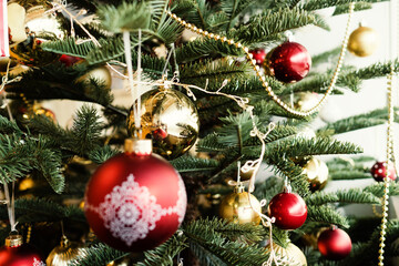 Artificial Christmas Tree with red and gold ornaments and Christmas decoration balls with pattern.