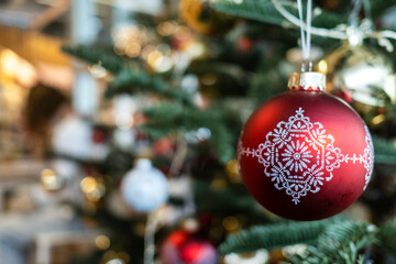 Artificial Christmas Tree with red and gold ornaments and Christmas decoration balls with pattern.