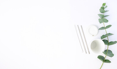 Stylish reusable eco coffee cup and metallic steel straws on green , flat lay. Ban single use...