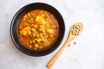 Indian popular homemade Aloo Matar. Potatoes and peas curry. Vatana batata bhaji or sabzi. with cooking ingredients along with copy space.