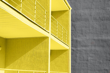 Blick auf gelbe und graue Wandstruktur Betongebäude mit Balkon. Konzept der Farbe des Jahres 2021