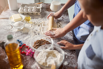 Person rolling out ready-made dough on table surface