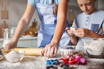 Two siblings making dough in the kitchen