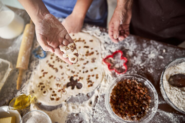 Obraz na płótnie Canvas Family activity of making gingerbread men with dash of raisins