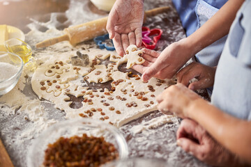 Cooks working at table covered with dough and food supplies